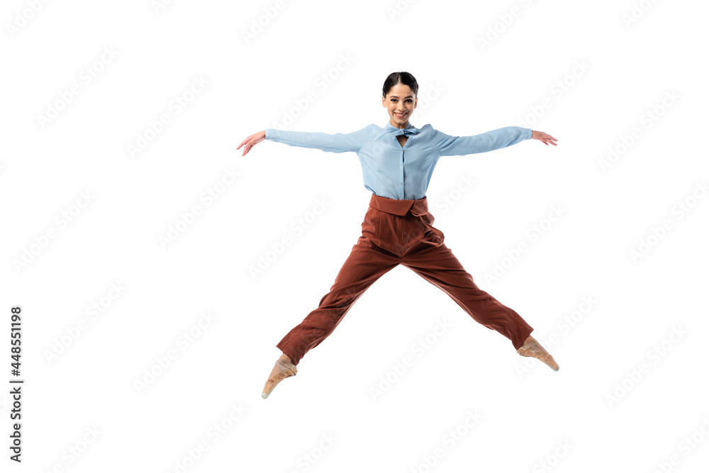 Ballerina smiling at camera while jumping isolated on white