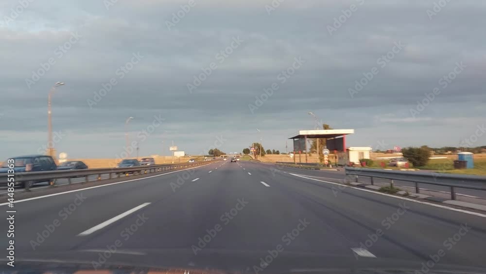 Suburban motorway in the summer evenings. View from the windshield of a car. Traffic from cars, background. Copy space for text Suburban motorway in the summer evenings. View from the windshield of a car. Traffic from cars, background. Copy space for text