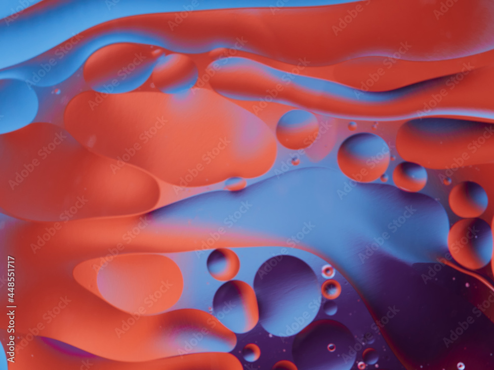 Fototapeta Closeup of oil drops motion on water surface. Colorful abstract macro background of oil drops on water surface with air bubbles inside