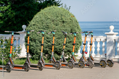 row of parked scooters on the city sidewalk, electric vehicle photo