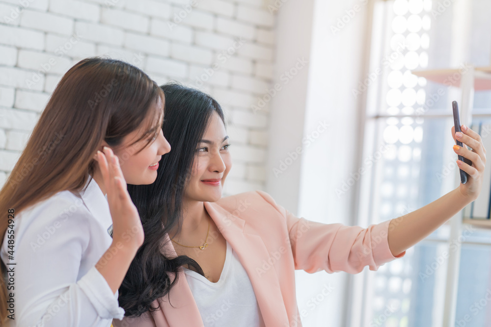 Beautiful young business women are selfie with her friend by cellphone or smartphone at living room. Happy friendship relationship concept Beautiful young business women are selfie with her friend by cellphone or smartphone at living room. Happy friendship relationship concept