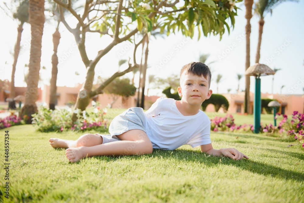 cute little boy lying on a green lawn