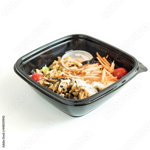 Poke with chicken  in a black plastic bowl on a white background isolated . Menu . Havaiian dish photo