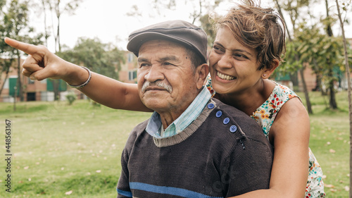 older man being hugged by his middle-aged daughter in the park