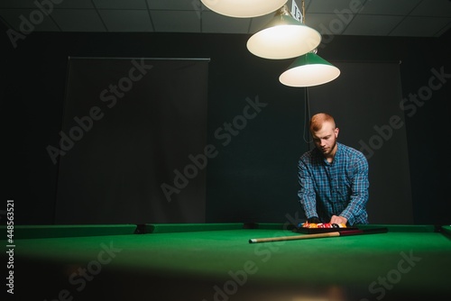 Man playing billiards in a club photo