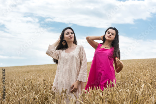 two pretty sister enjoy freedom in wheat field