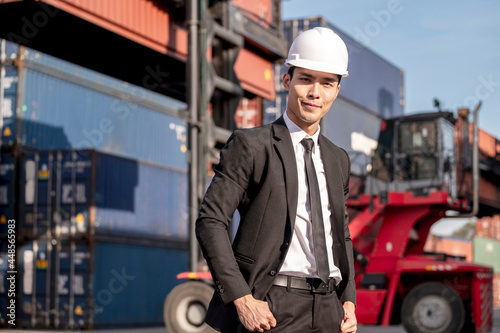 Obraz na płótnie Happy Asian businessman working with smile servic in shipping containerin commercial transport background. w salonie