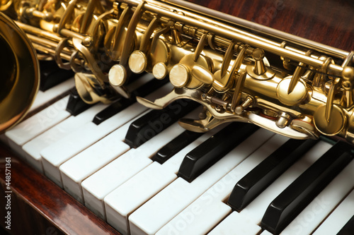 Photography Beautiful saxophone on piano keys, closeup. Musical instruments