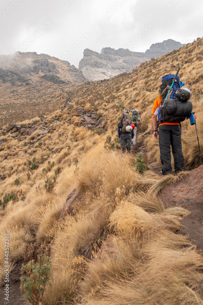 Mountaineer seen from the back looking up the mountain