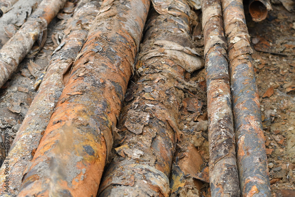 Many used rusty metal pipes taken out of the ground. Selective focus. Many used rusty metal pipes taken out of the ground. Selective focus.
