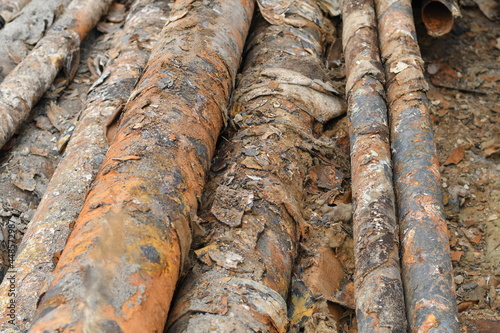 Many used rusty metal pipes taken out of the ground. Selective focus. 