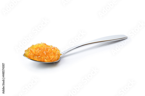 Orange  jam in stainless spoon isolated on white background