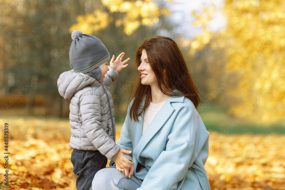 Mother hugs toddler boy ion golden autumn background Mother hugs toddler boy ion golden autumn background