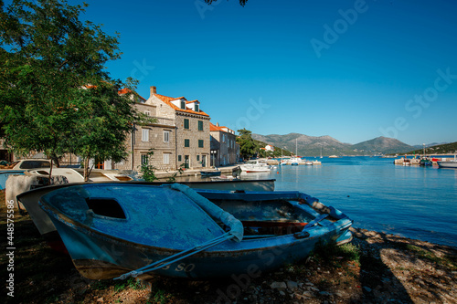 An old abandoned wooden boat off the coast of an island in Croatia. View of the fishing village photo
