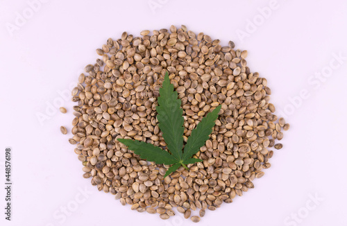 Hemp seeds with hemp leaves on a white background. View from above. © Olivka888
