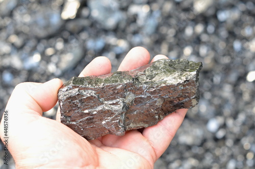 Vászonkép A piece of coarse anthracite coal lies in a man's hand.