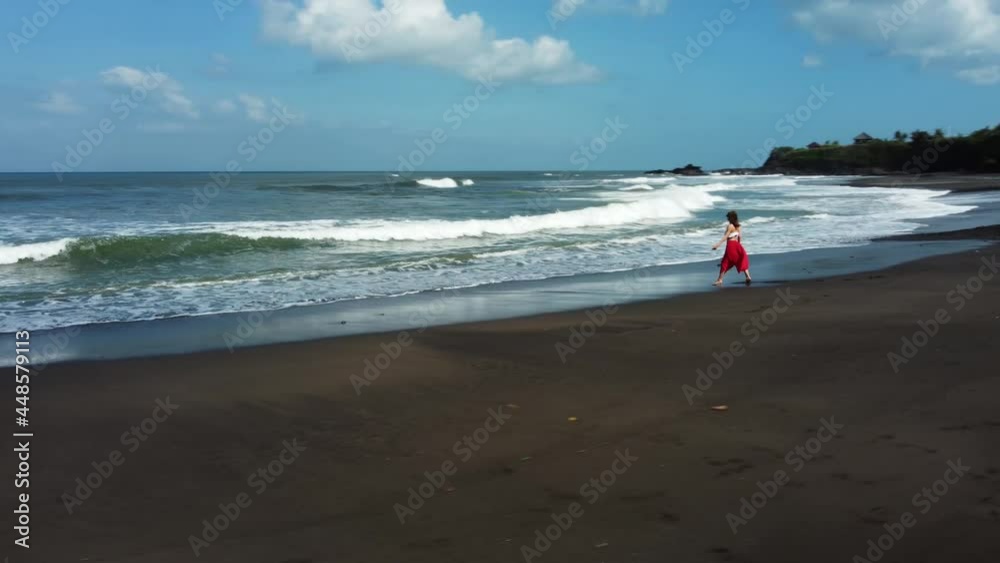 Young woman walking on black sand Bailan beach Bali. High quality 4k footage Young woman walking on black sand Bailan beach Bali. High quality 4k footage