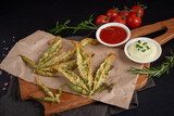 Homemade marijuana fries with mayonnaise, tomato sauce and rosemary on wooden board. Concept of cooking with cannabis herb. Treatment of medical marijuana for food use,on black background CBD use