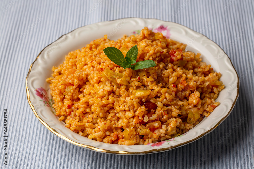 Traditional turkish bulgur pilaf with tomato sause in plate (Turkish name; meyhane pilavi) Traditional turkish bulgur pilaf with tomato sause in plate (Turkish name; meyhane pilavi)