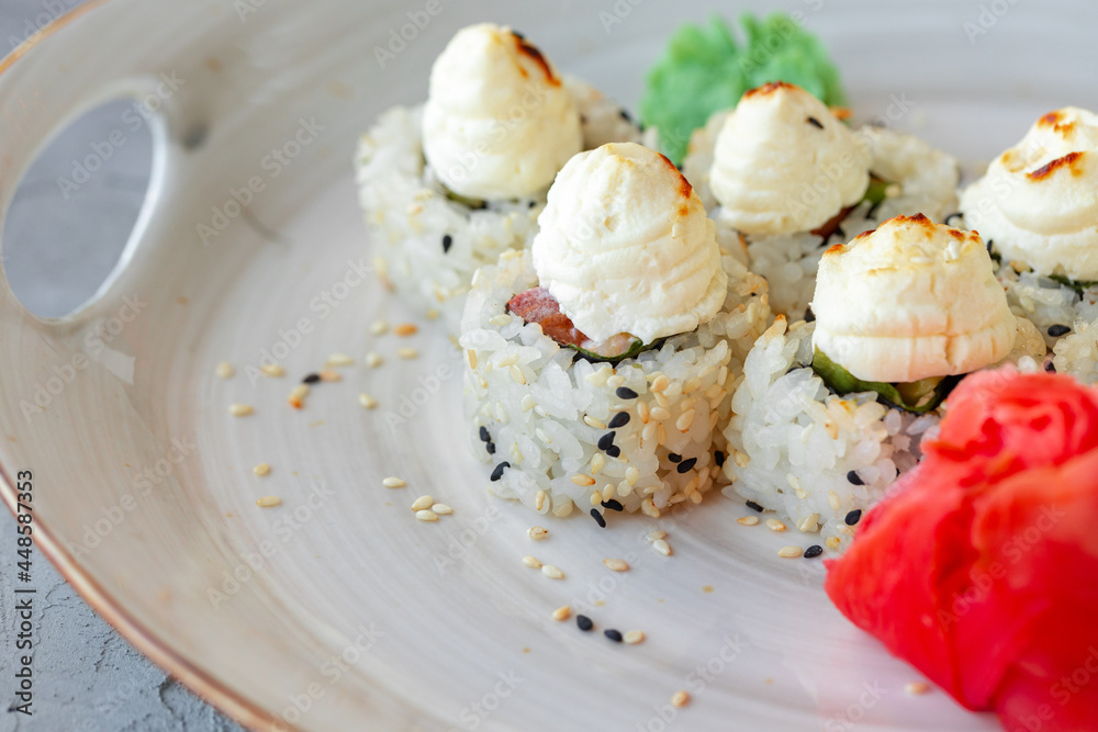 Japanese sushi with sesame seeds and cream icing on gray background Japanese sushi with sesame seeds and cream icing on gray background
