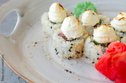 Japanese sushi with sesame seeds and cream icing on gray background