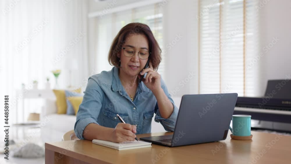 Asia adult people or SME owner woman leader moody sitting tired busy phone call work on laptop computer at desk house office think worry concern give advice on distance job crisis corporate trouble. Asia adult people or SME owner woman leader moody sitting tired busy phone call work on laptop computer at desk house office think worry concern give advice on distance job crisis corporate trouble.