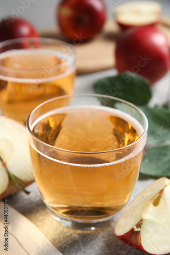 Delicious cider and ripe apple on table, closeup