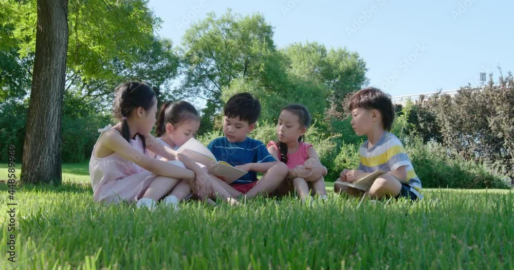 Happy children reading book on meadow,4K Happy children reading book on meadow,4K