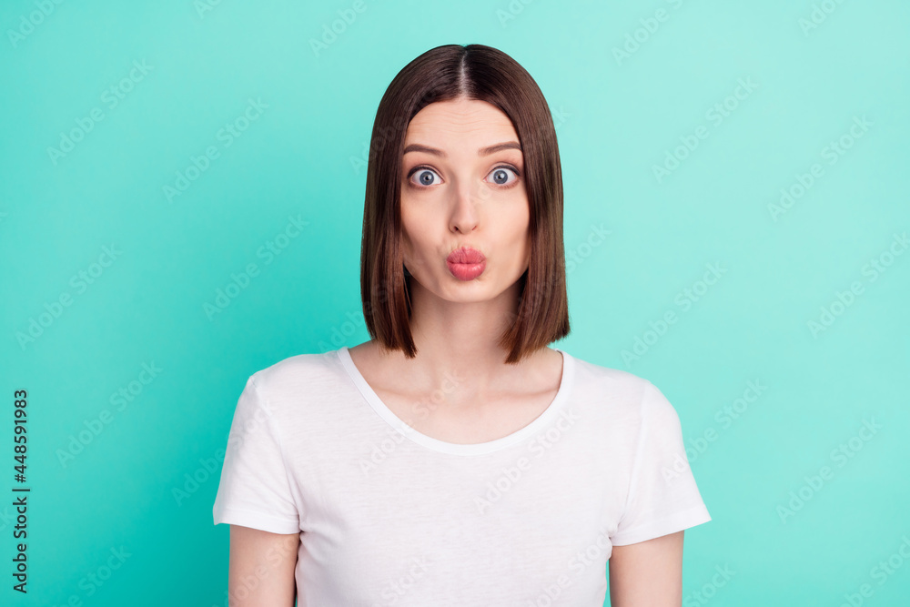Fototapeta premium Portrait of attractive girlish affectionate girl sending air kiss isolated over bright teal turquoise color background