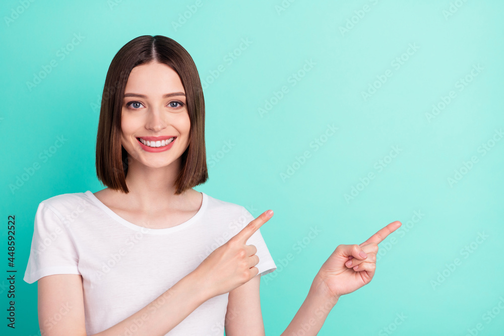 Photo of cheerful young happy nice woman point finger empty space news isolated on teal color background Photo of cheerful young happy nice woman point finger empty space news isolated on teal color background