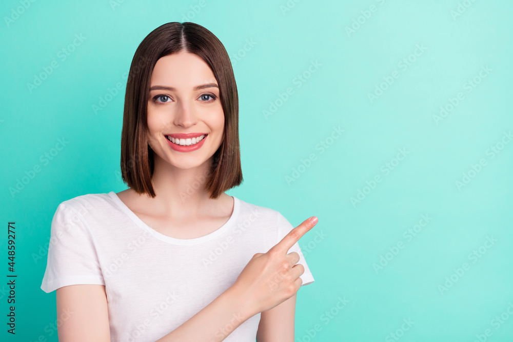 Portrait of attractive cheerful brown-haired girl demonstrating copy empty space isolated over bright teal turquoise color background Portrait of attractive cheerful brown-haired girl demonstrating copy empty space isolated over bright teal turquoise color background