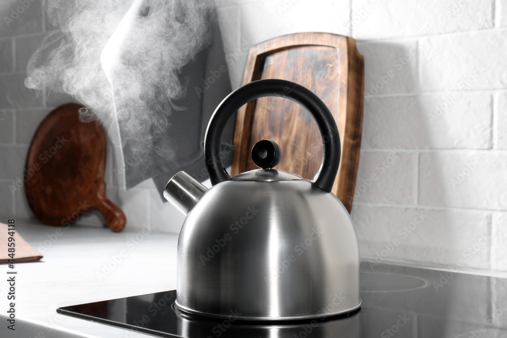 Steaming kettle on electric stove in kitchen Steaming kettle on electric stove in kitchen