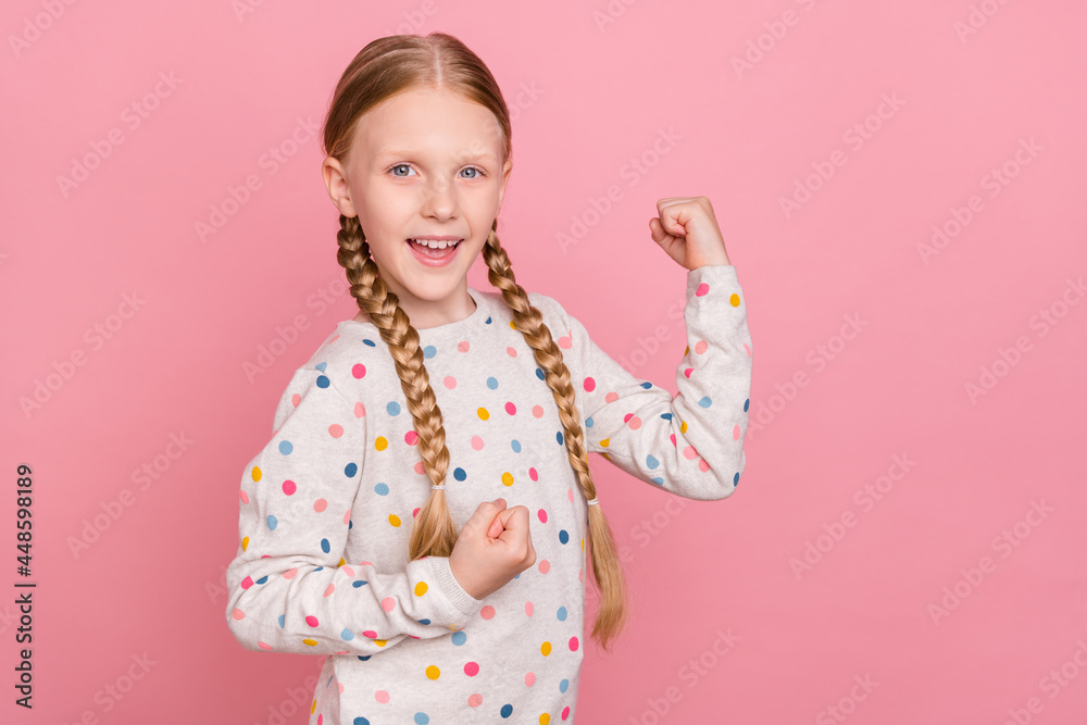 Photo of funny lucky schoolgirl dressed dotted sweater smiling rising fists isolated pink color background Photo of funny lucky schoolgirl dressed dotted sweater smiling rising fists isolated pink color background