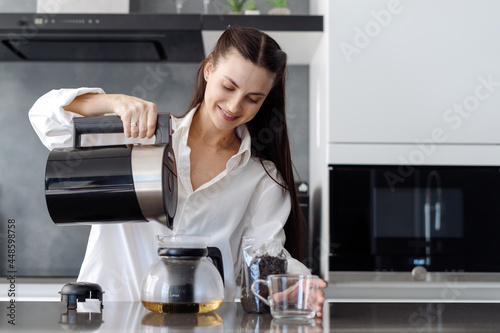 Woman pouring hot water into teapot