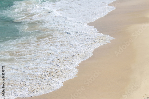 White water from waves on a sandy beach on a summer day