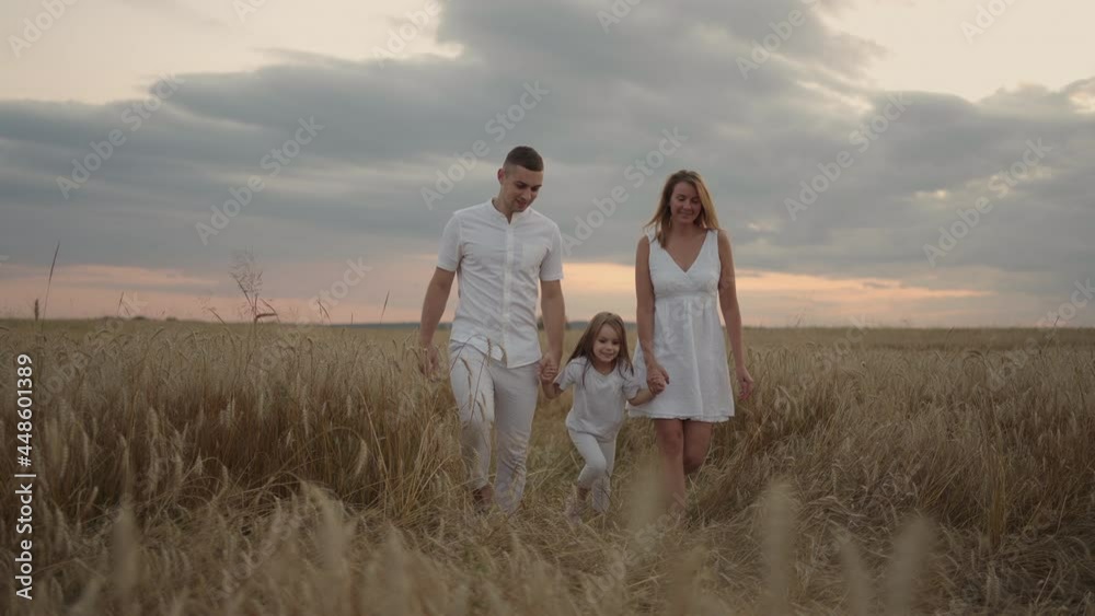 Slow motion: Happy family of farmers with child, are walking on wheat field. Healthy mother, father and little daughter enjoying nature together, outdoors. Slow motion: Happy family of farmers with child, are walking on wheat field. Healthy mother, father and little daughter enjoying nature together, outdoors.