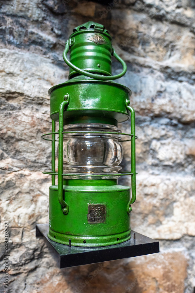 Old ship green lantern hanging on the wall. Vintage lights.