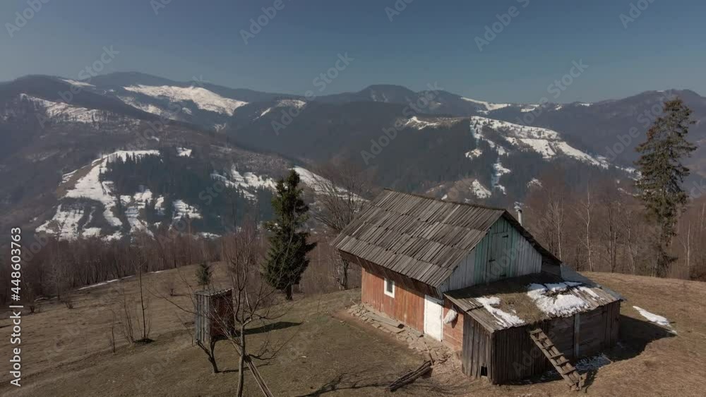Village house on a background of winter mountains. Aerial view of a beautiful panorama of the mountains.