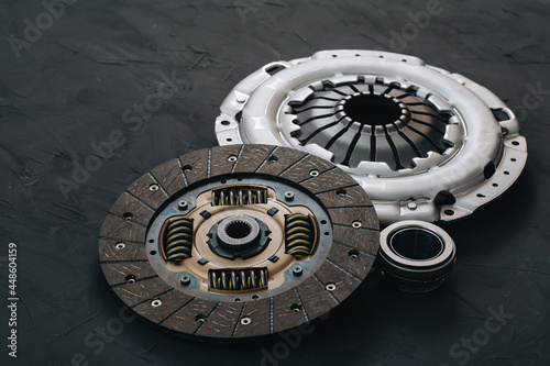 Automotive clutch mechanism, disc, basket and bearing for auto on a black background.