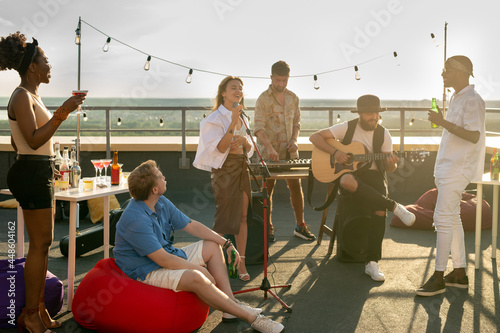 Sticker Music group performing for intercultural friends at rooftop party