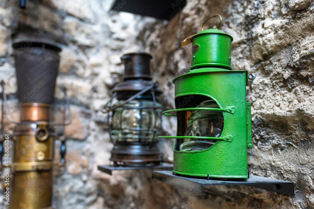 Old ship green lantern hanging on the wall. Vintage lights. Old ship green lantern hanging on the wall. Vintage lights.