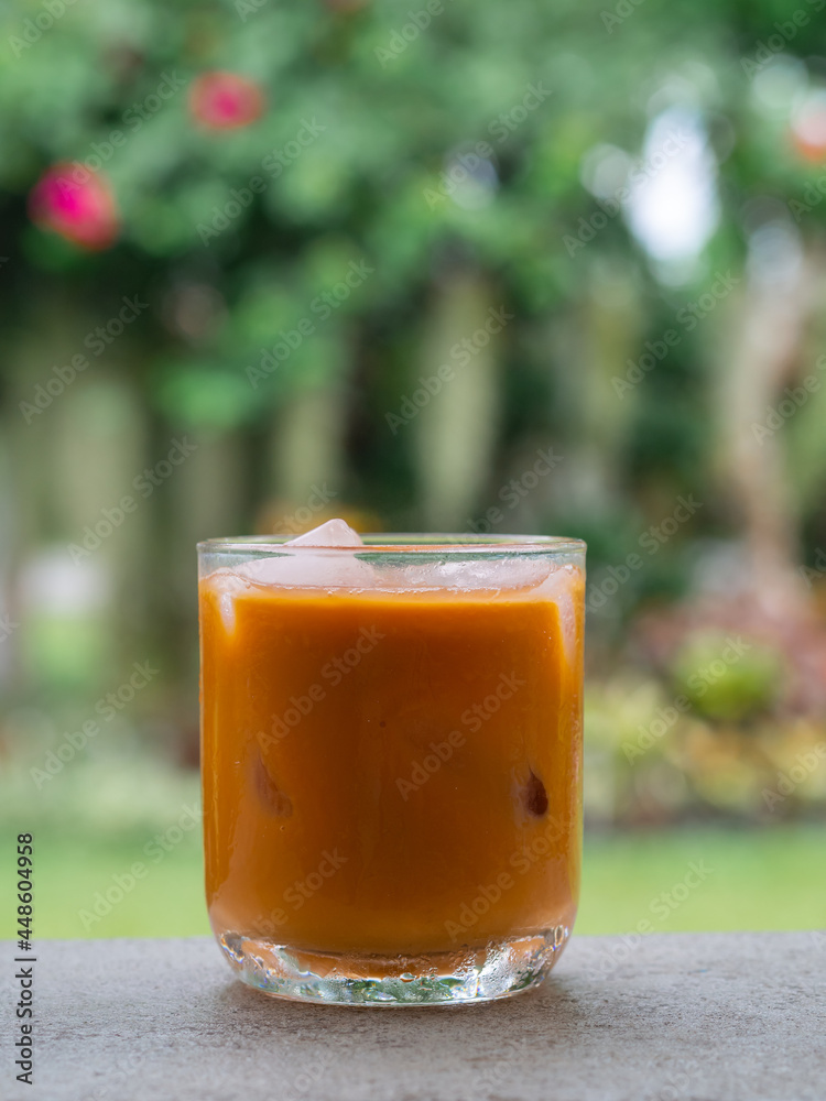 ice tea or ice thai tea in glass , fresh dessert in coffee cafe with nature background ice tea or ice thai tea in glass , fresh dessert in coffee cafe with nature background