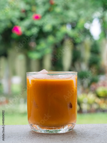 ice tea or ice thai tea in glass , fresh dessert in coffee cafe with nature background