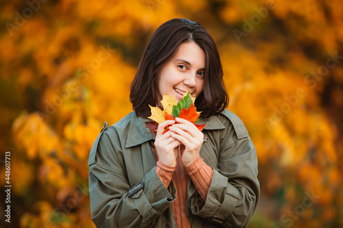 smiling woman in front of golden autumn leaves