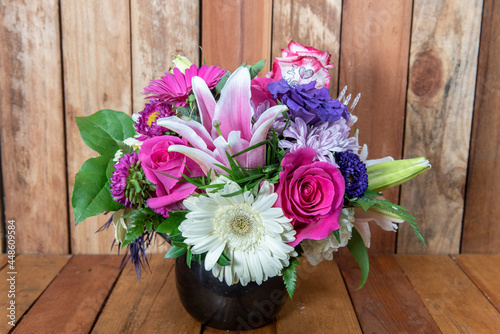 Beautiful bouquet of arranged stargazers, roses, mums, and white daisys displayed in a lovely vase photo