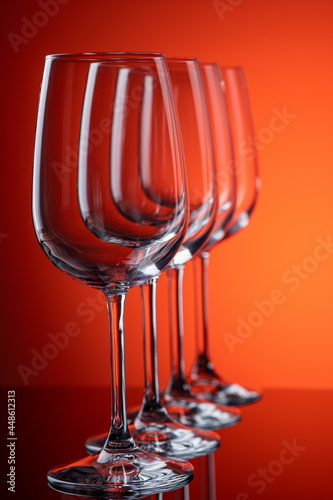 Four  wine glasses in row perspective on red-orange background