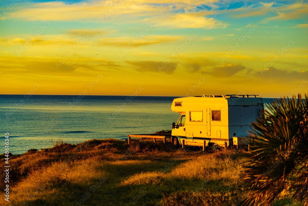 Camper vehicle on beach at sunrise