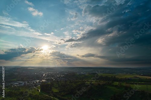 Aerial view of a german city near stuttgart. Just before sunset with beautiful cloudy sky. Rural area in foreground. Germany, Nurtingen. © Jan