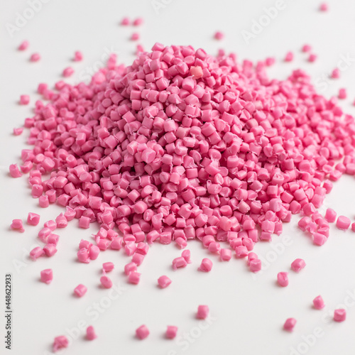 Pink granules of polypropylene or polyamide on a white background. Plastics and polymers industry. Copy space.