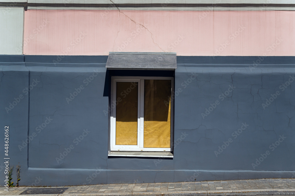 Facade of the house. The window is glued with yellow paper from the inside.